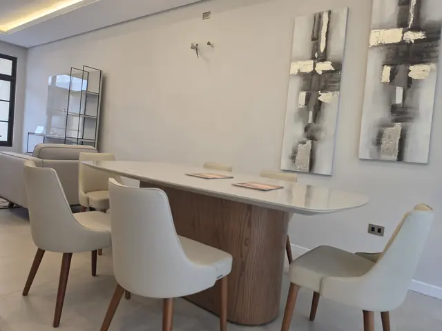 Comedor de la casa modelo con mesa ovalada para seis personas